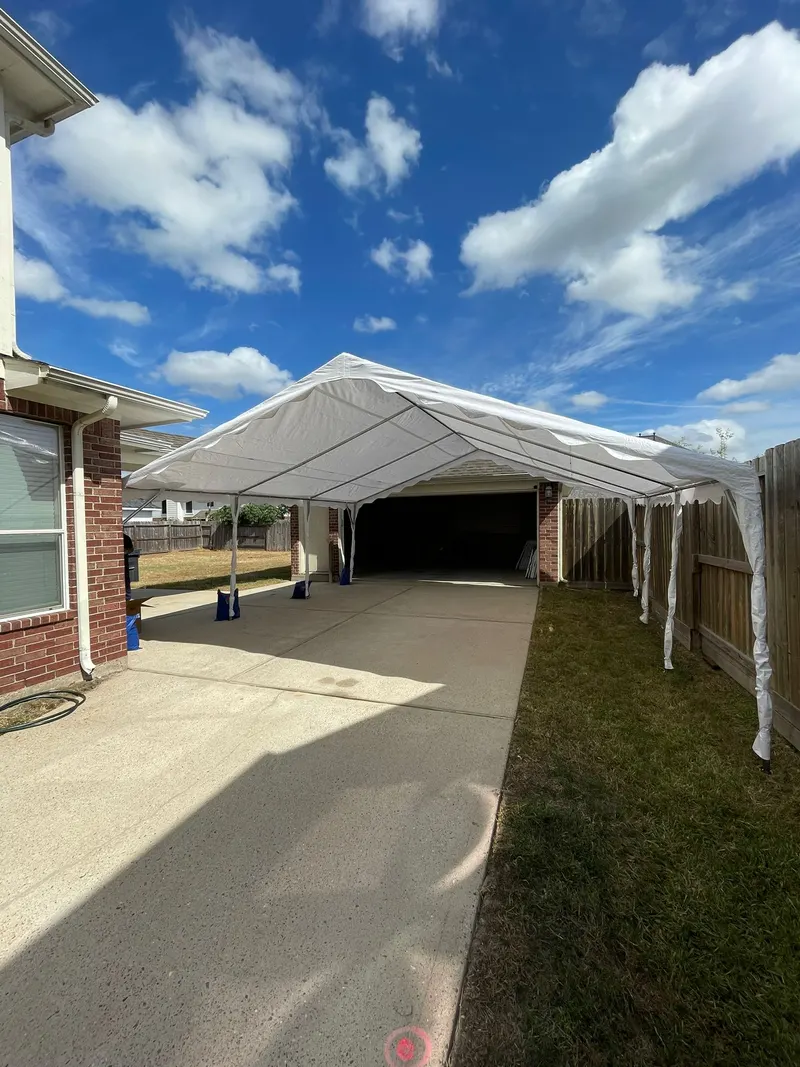 Large white frame tent set up over a driveway