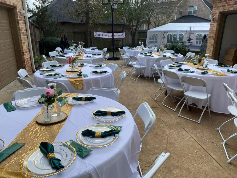 Birthday party with round tables, white covers and white folding chairs